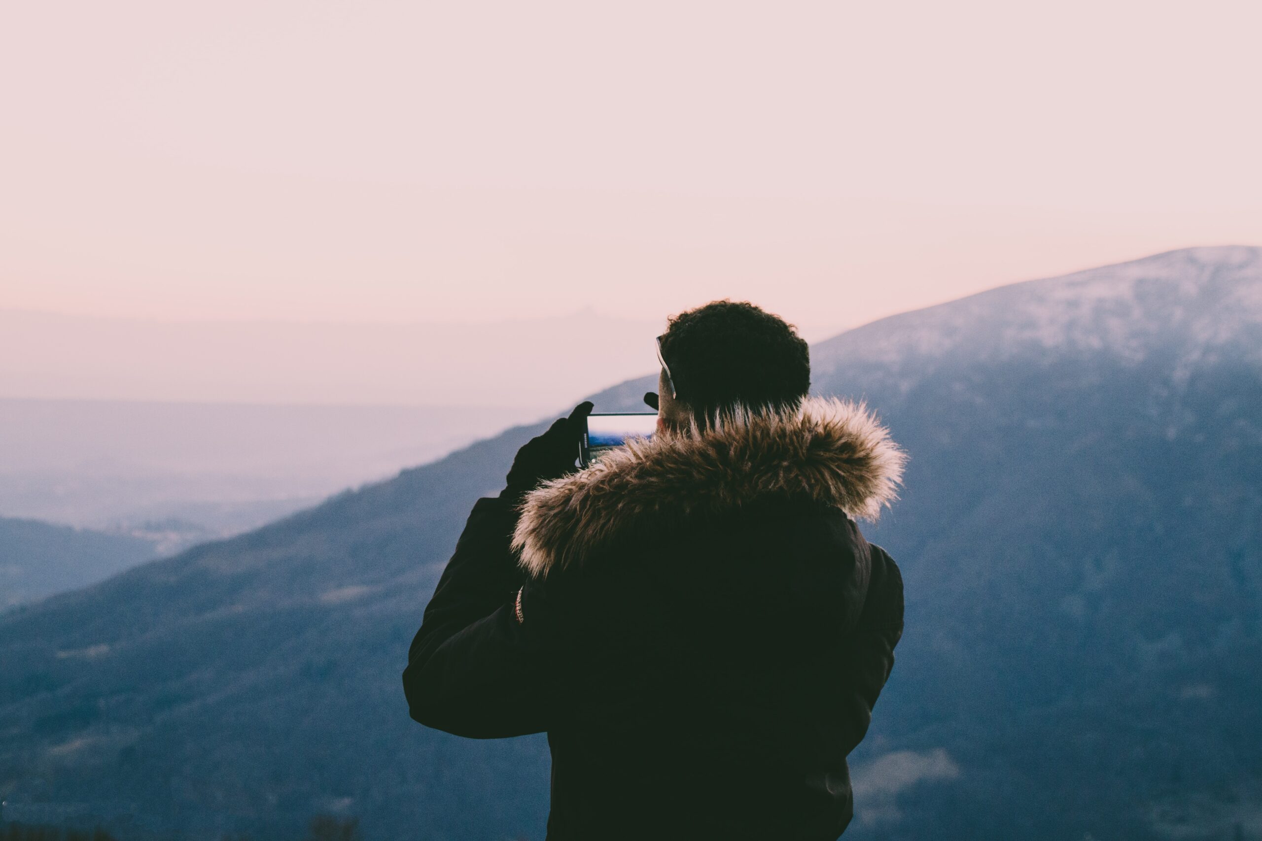 man taking photo on hills