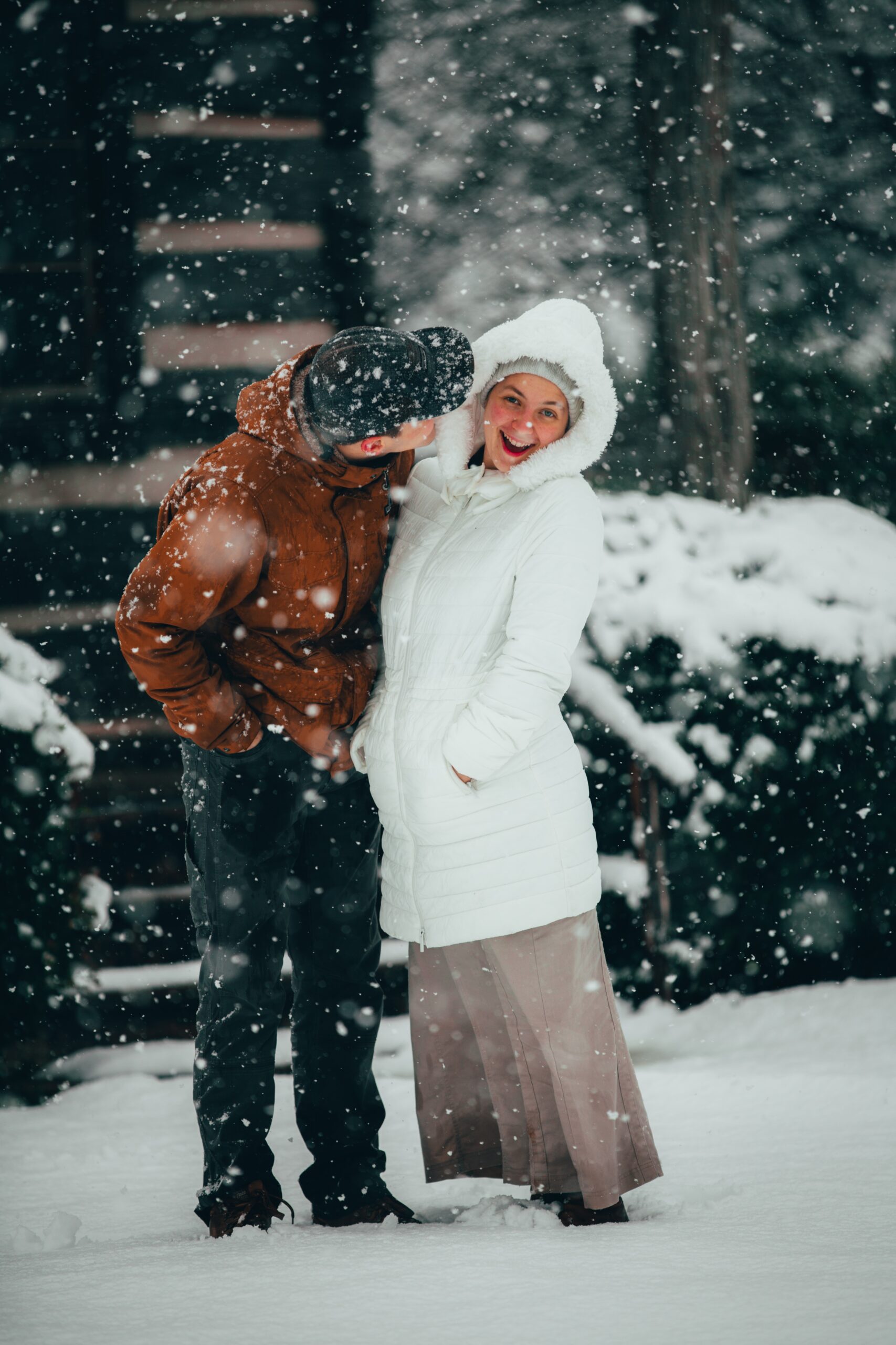 woman in white jacket and brown pants standing on snow covered ground during daytime