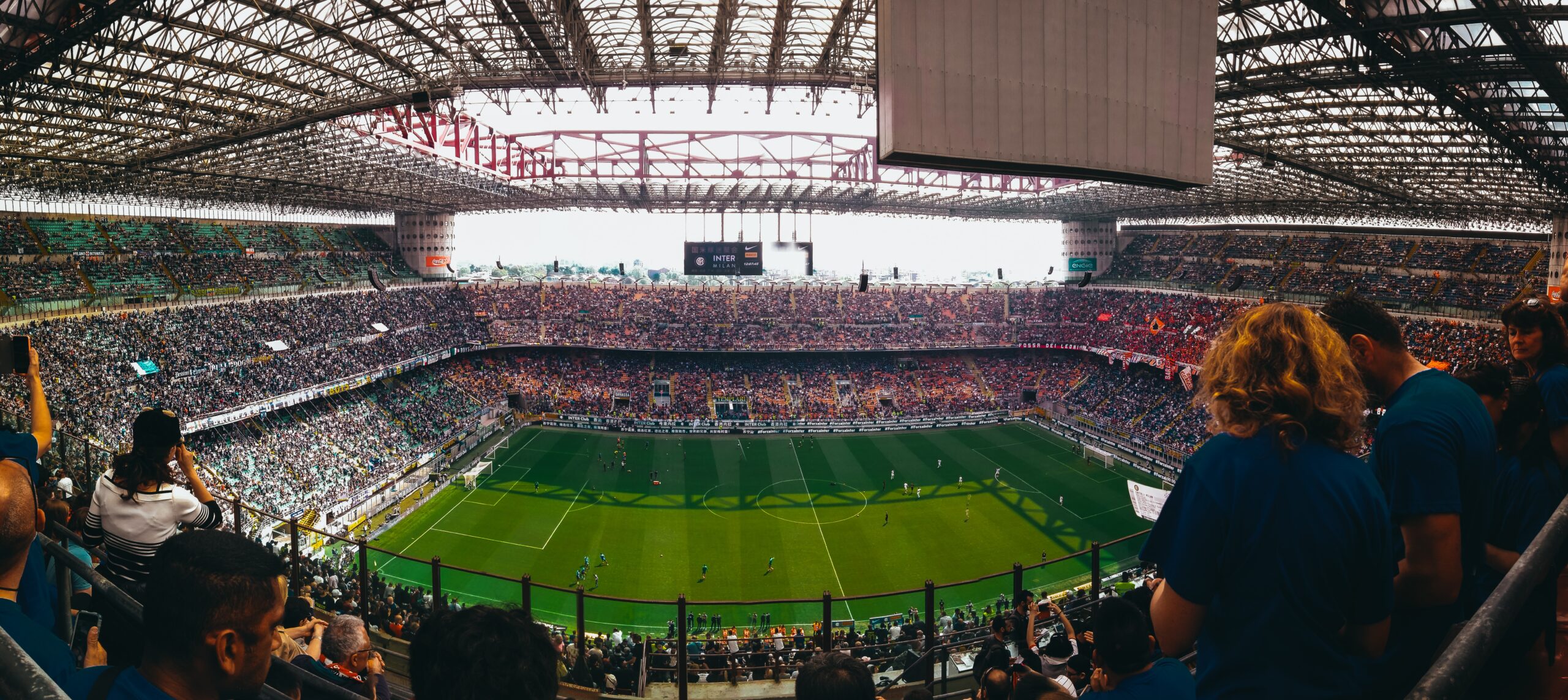 people watching soccer game during daytime