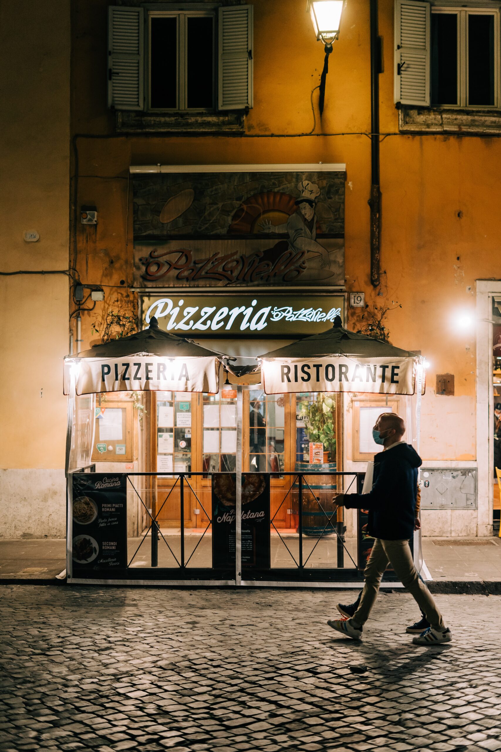 A white neon sign of a pizzeria in Rome, Italy