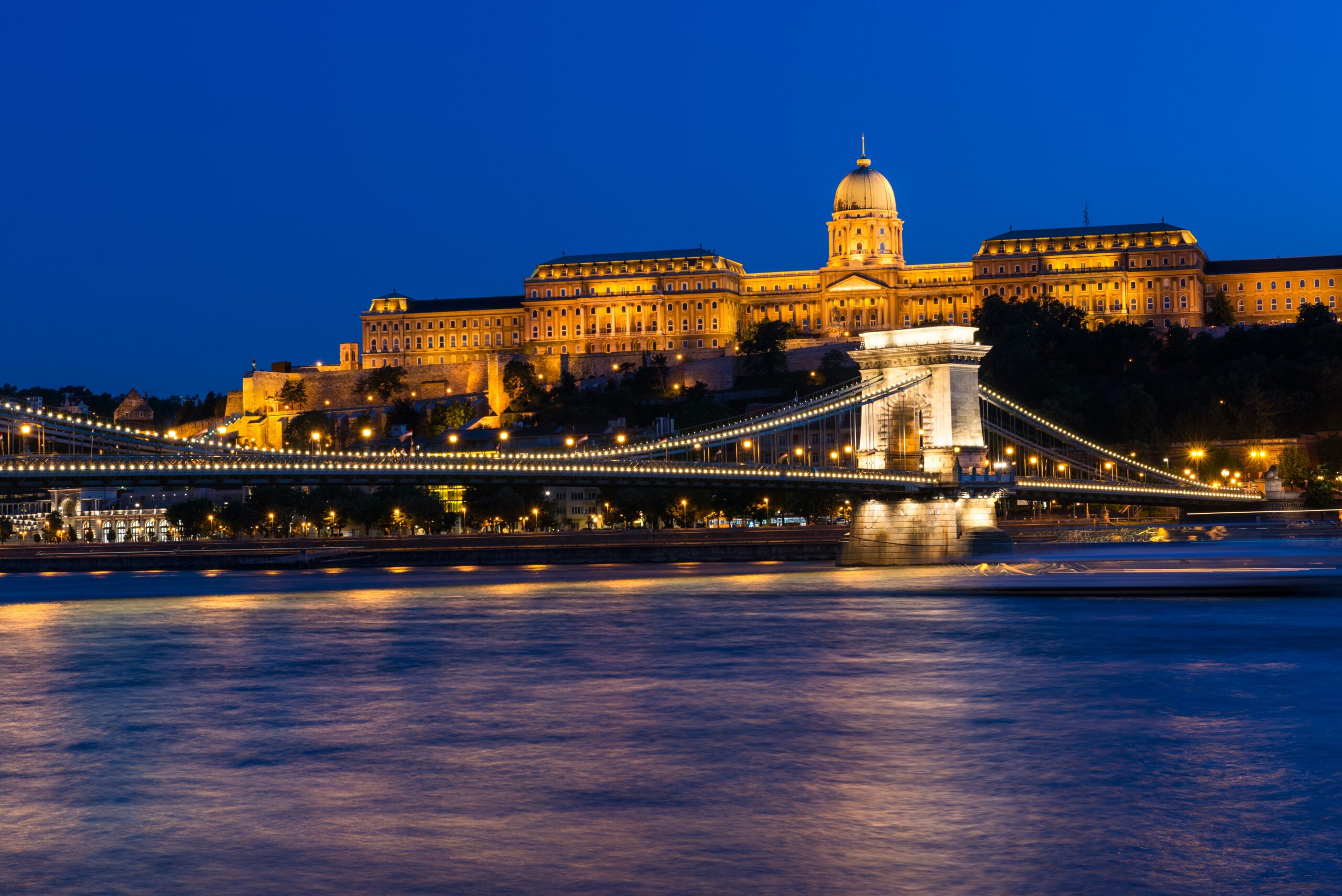 Night view of some of the most famous Hungarian landmarks, including the Széchenyi Chain Bridge and the Royal Palace as seen from the other side of the Danube river. Long Exposure.