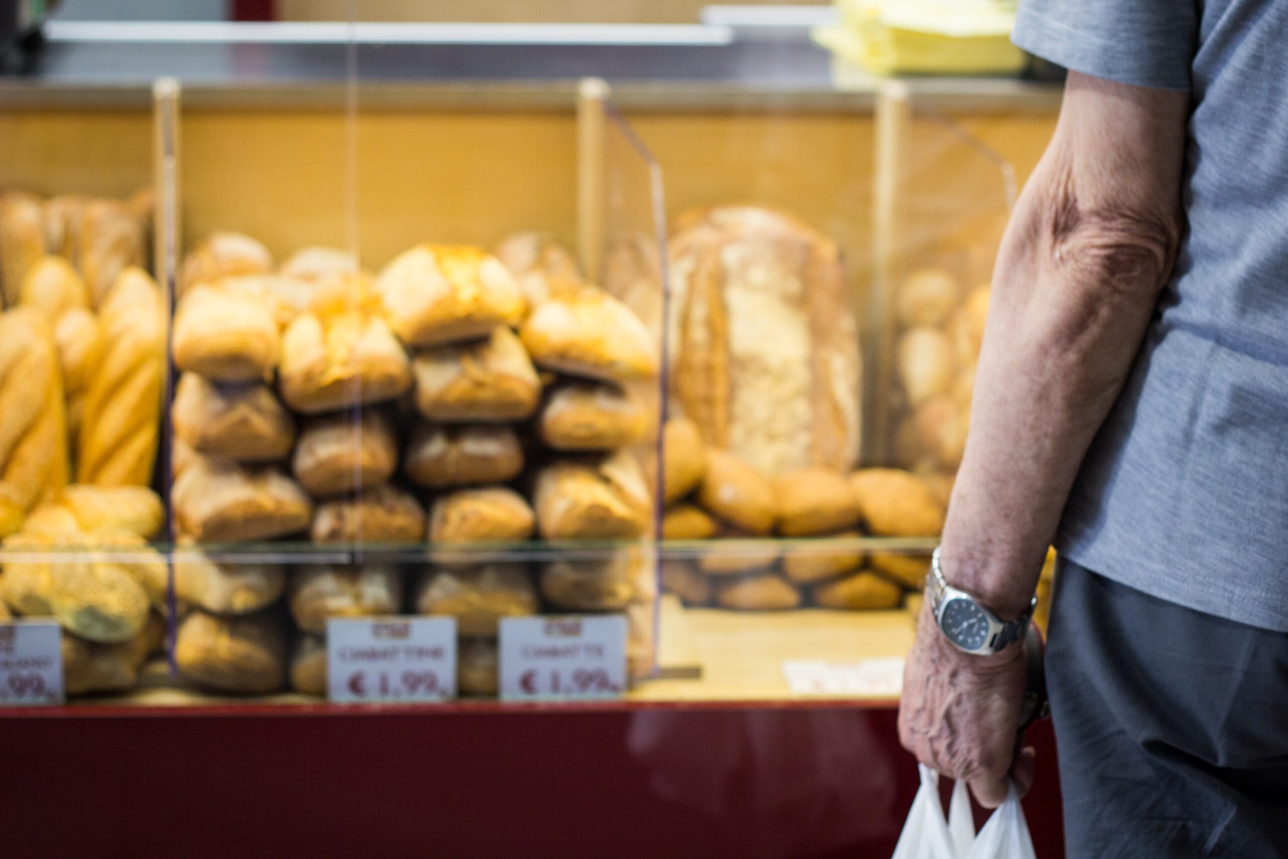 person in white long sleeve shirt with black leather strap watch holding brown bread