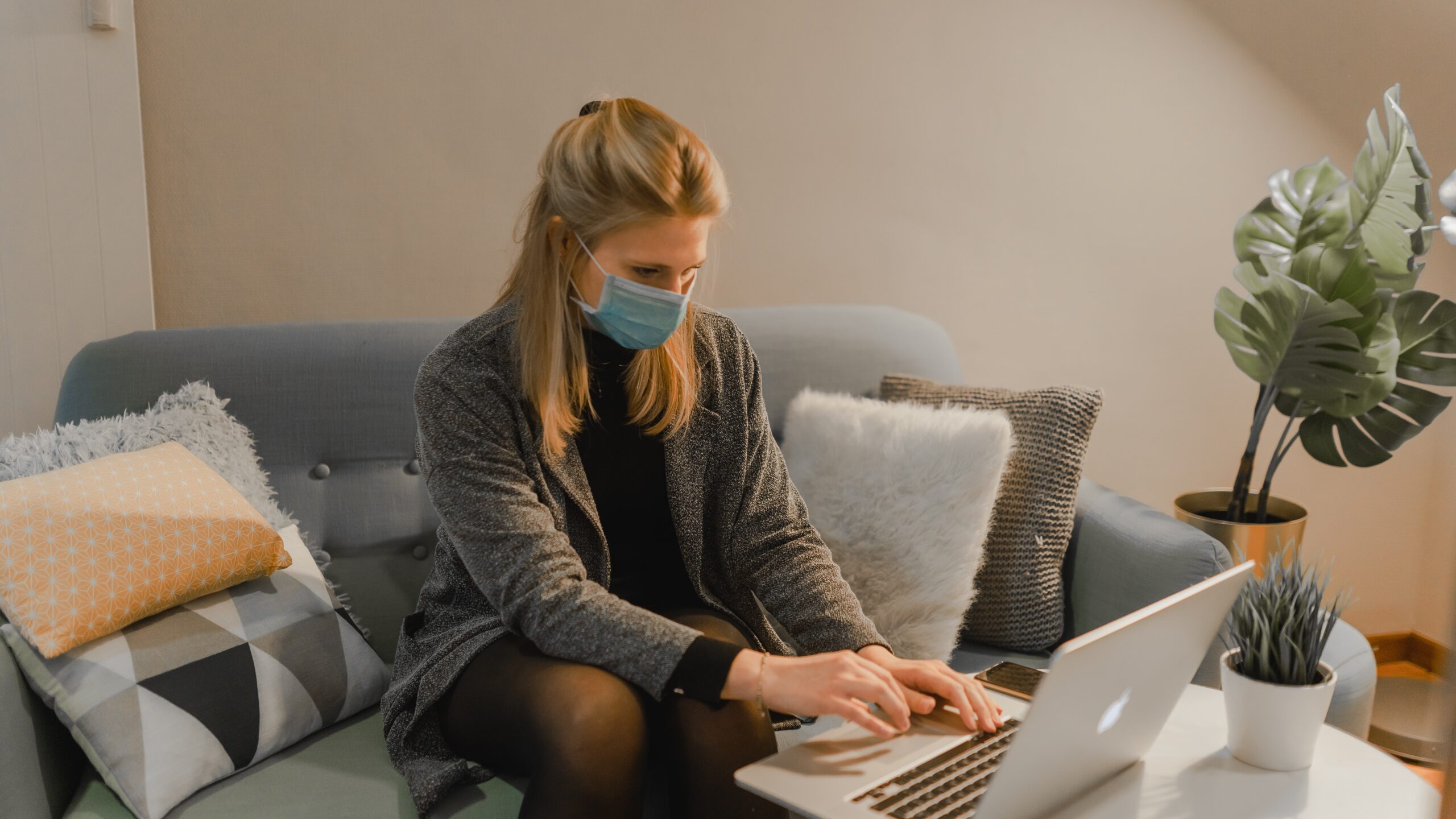 woman in gray sweater using laptop computer