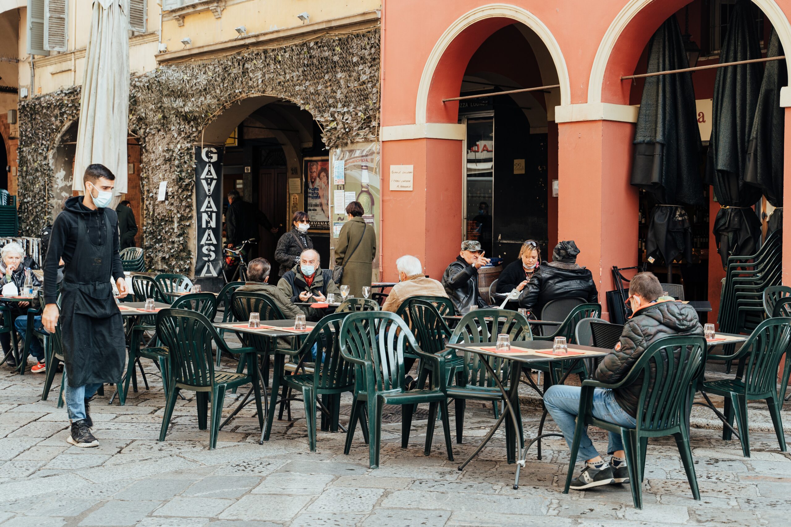 people sitting on green chairs near brown concrete building during daytime