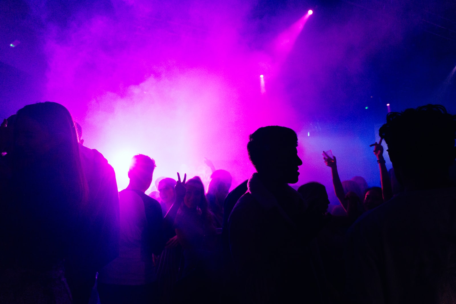 people standing on stage with purple lights