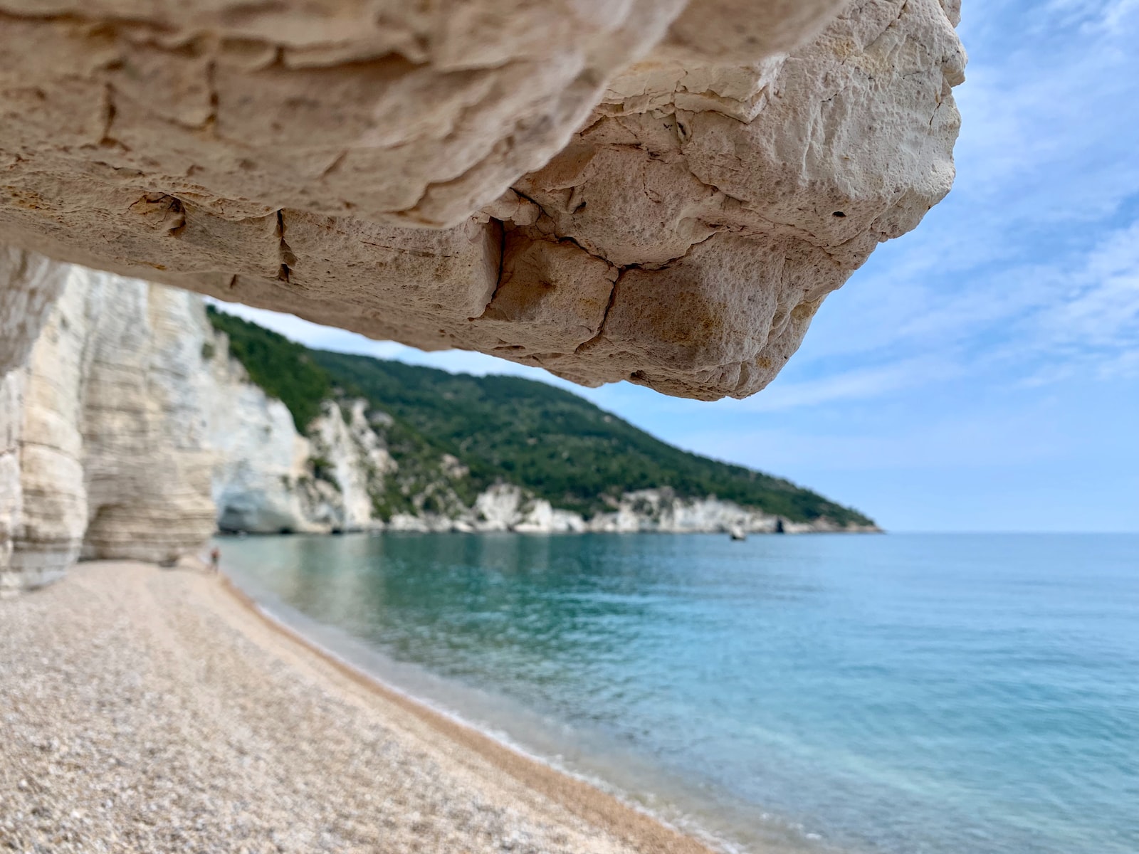 green and brown cliff beside ocean