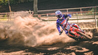 person riding on motocross dirt bike drifts on race track
