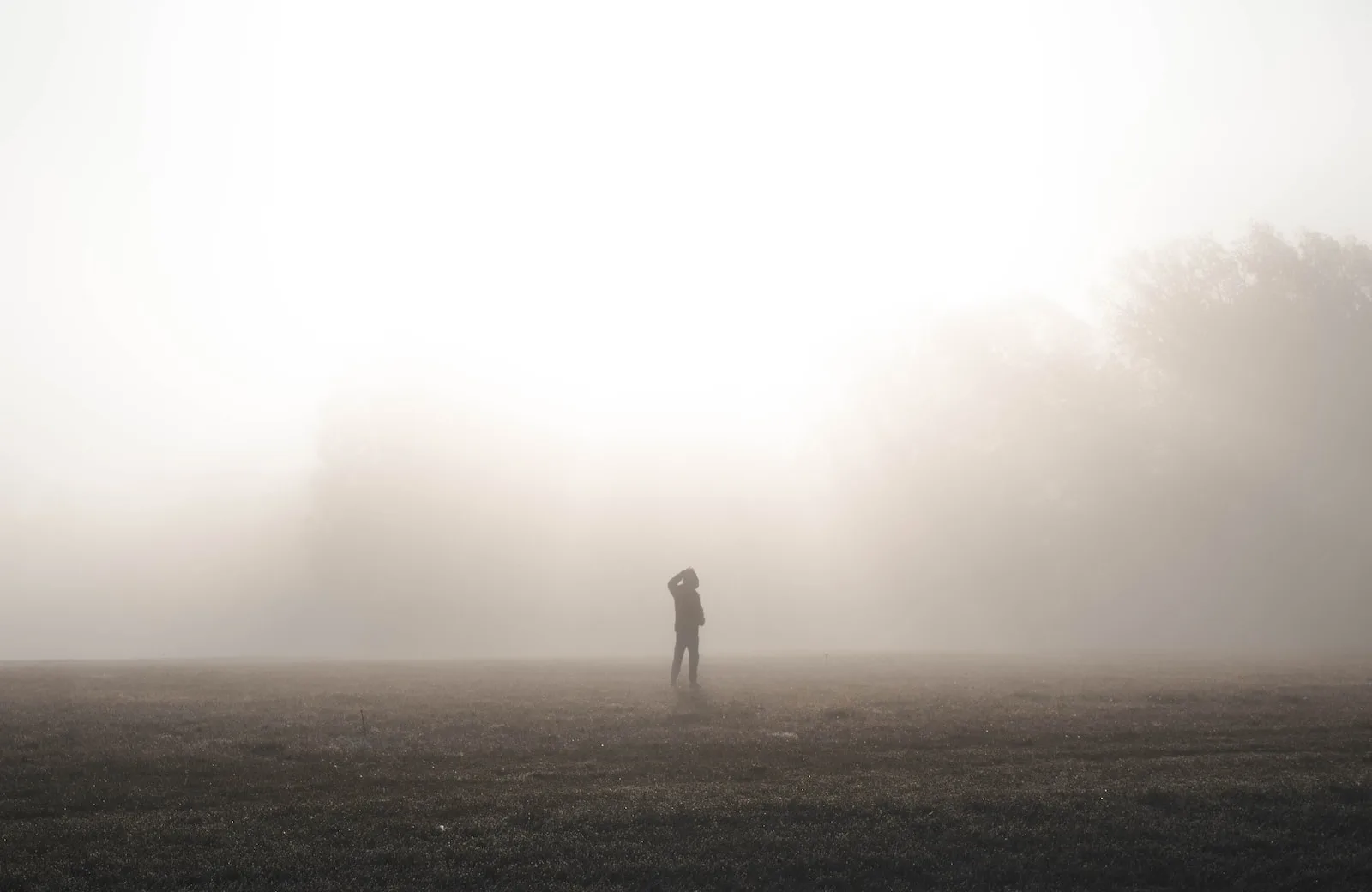 silhouette of person in dirt road