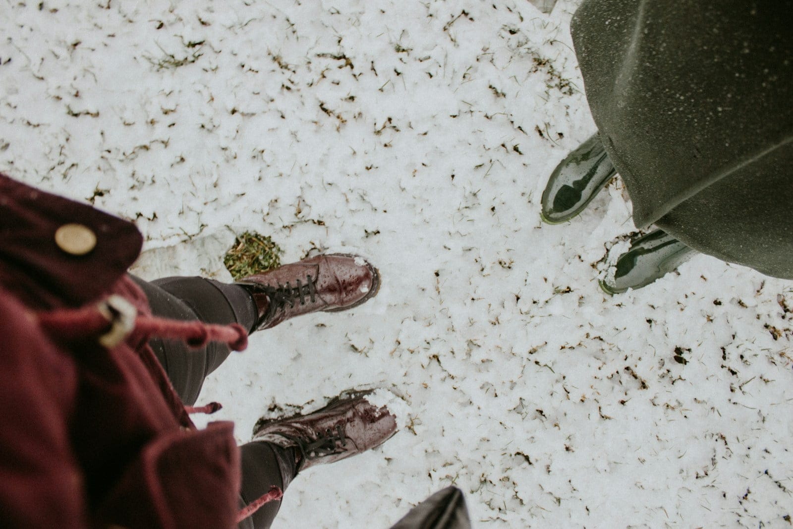 two people standing in the snow looking down