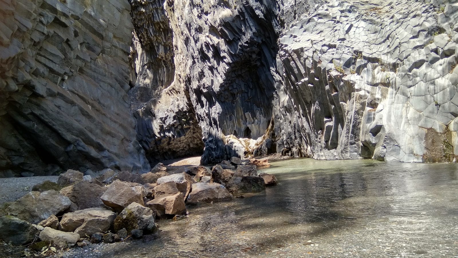 gray rocky mountain near body of water during daytime