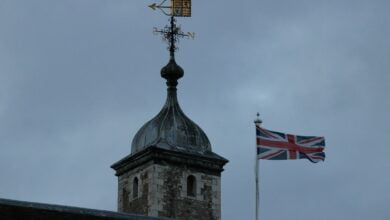 a tower with a clock and a flag on top of it