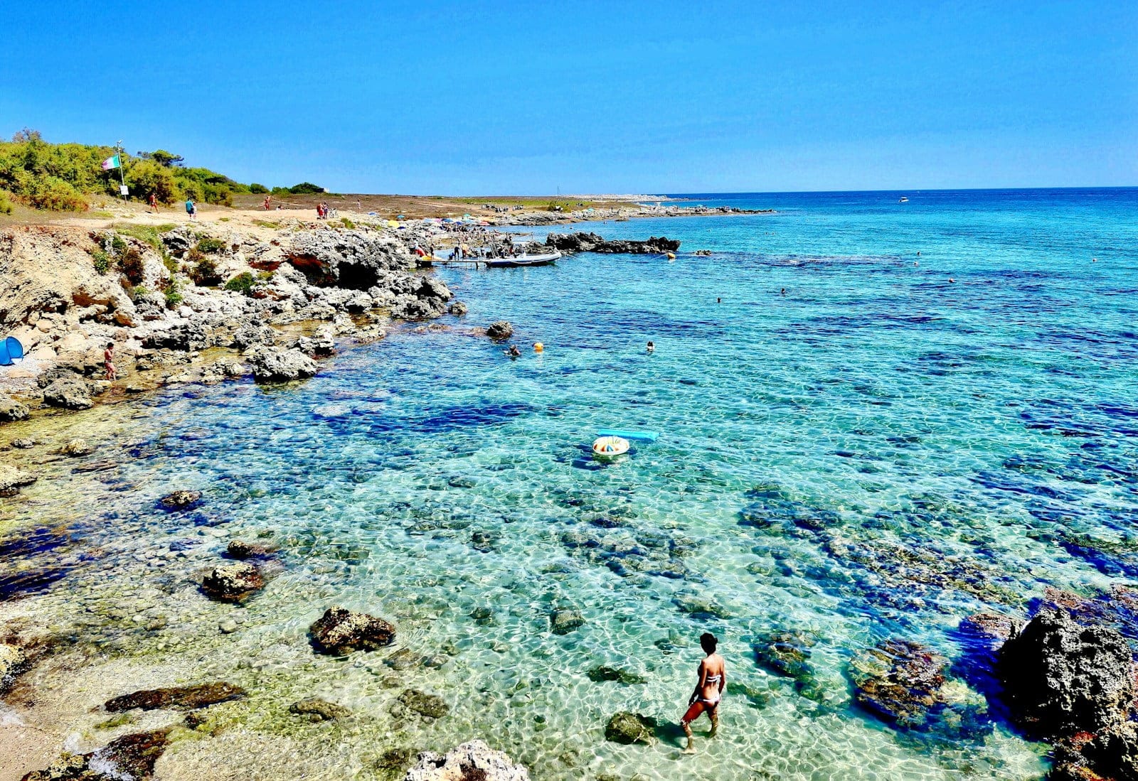 woman in red bikini standing on seashore during daytime