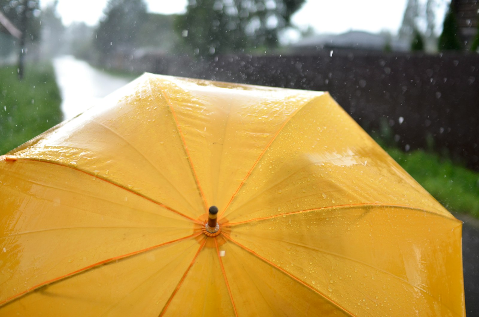 a yellow umbrella sitting on the side of a road