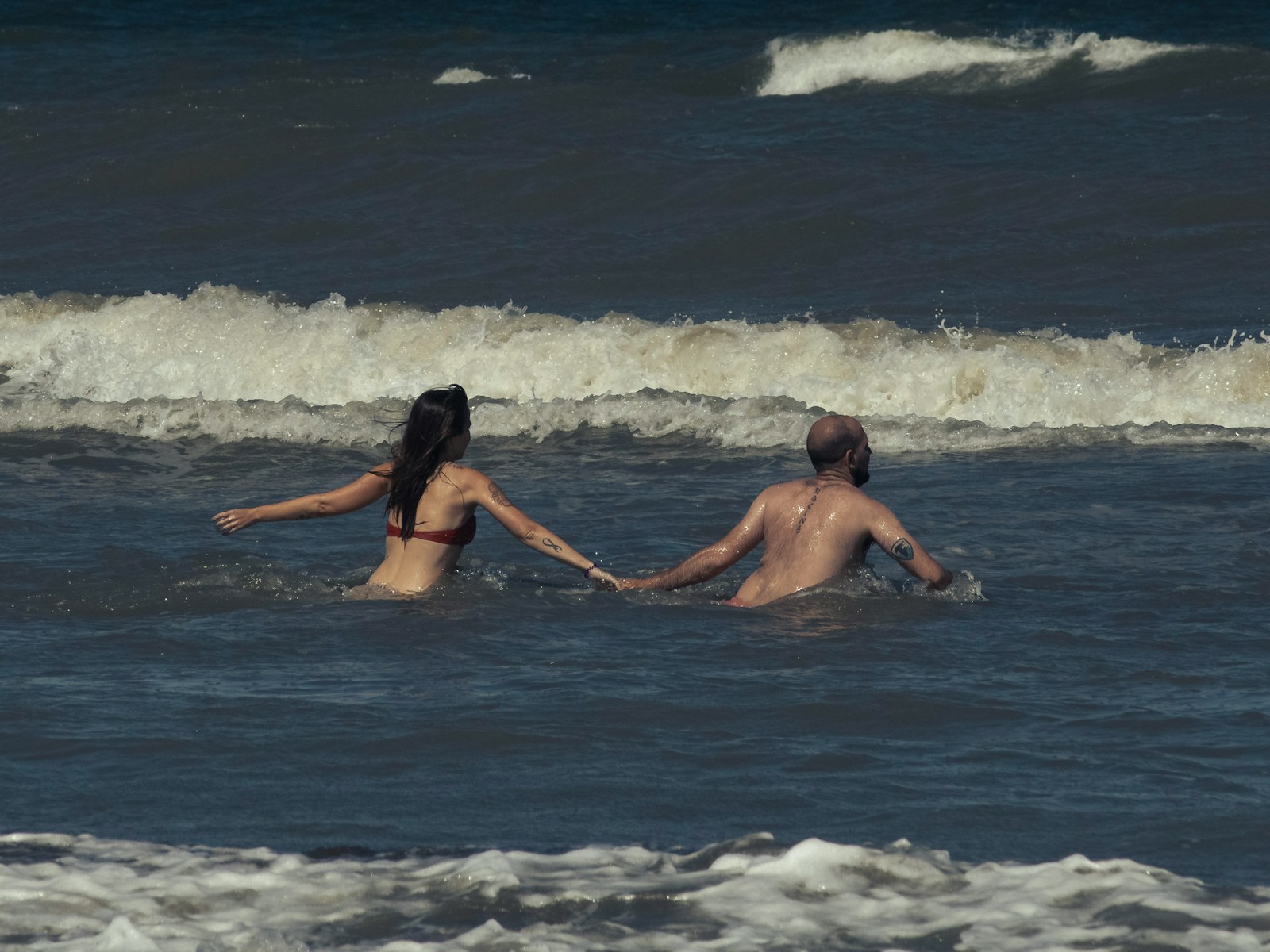 man and woman in water during daytime