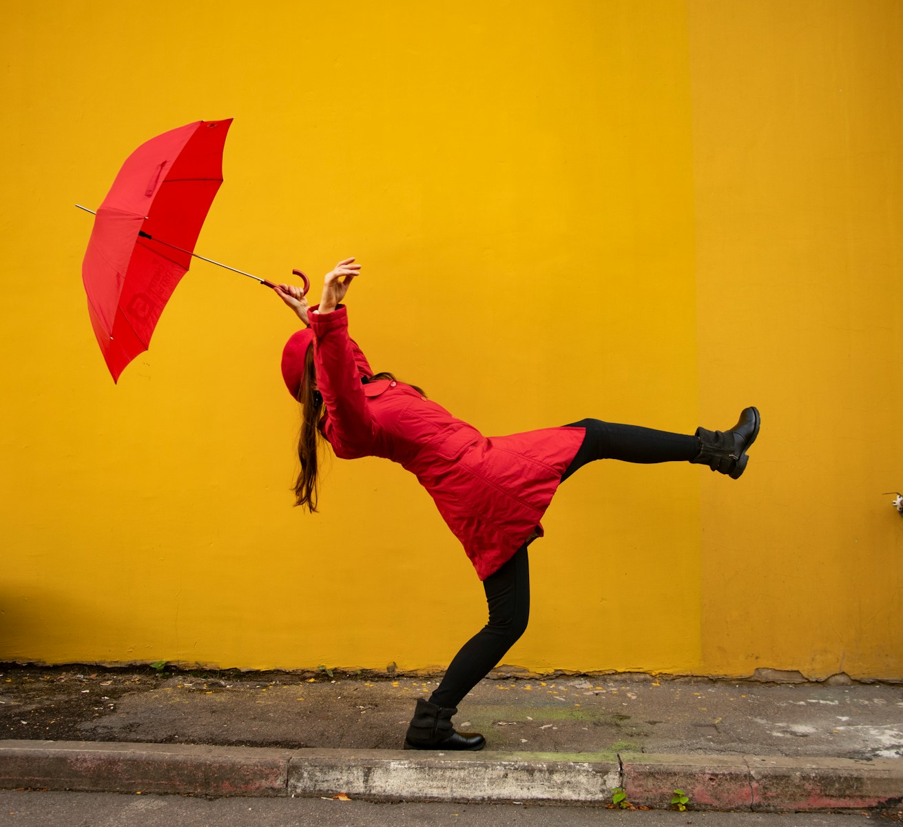 A woman in a red dress holding a red umbrella