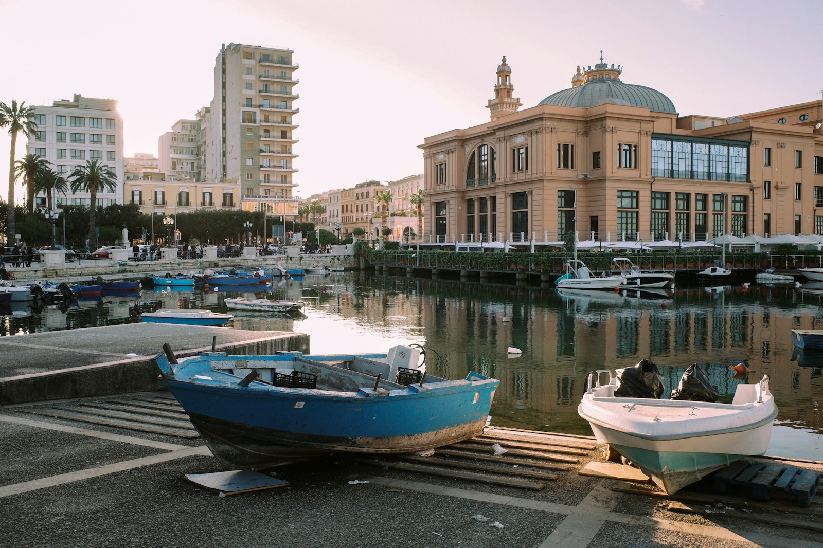 Several boats are docked in a harbor in a city