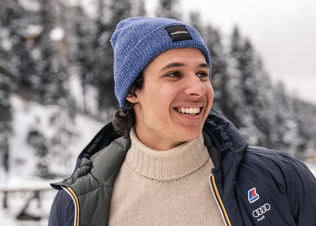 Matteo Franzoso in montagna con abbigliamento tecnico e sorriso, ritratto in ambiente innevato.