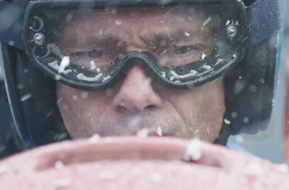 Giorgio Pasotti in Rosso Volante durante una gara di bob alle Olimpiadi invernali, primo piano con casco e neve