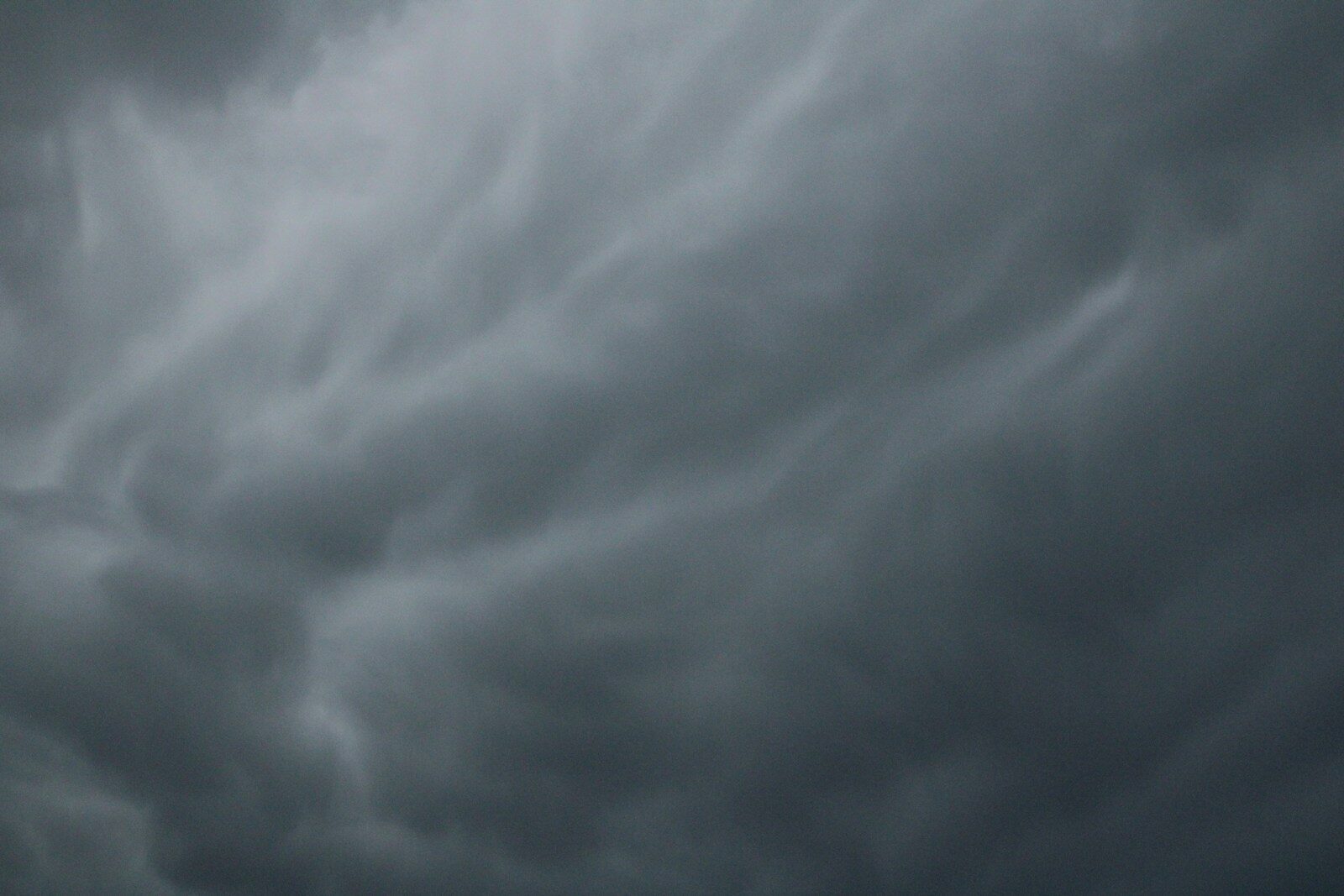 a plane flying through a cloudy sky on a cloudy day