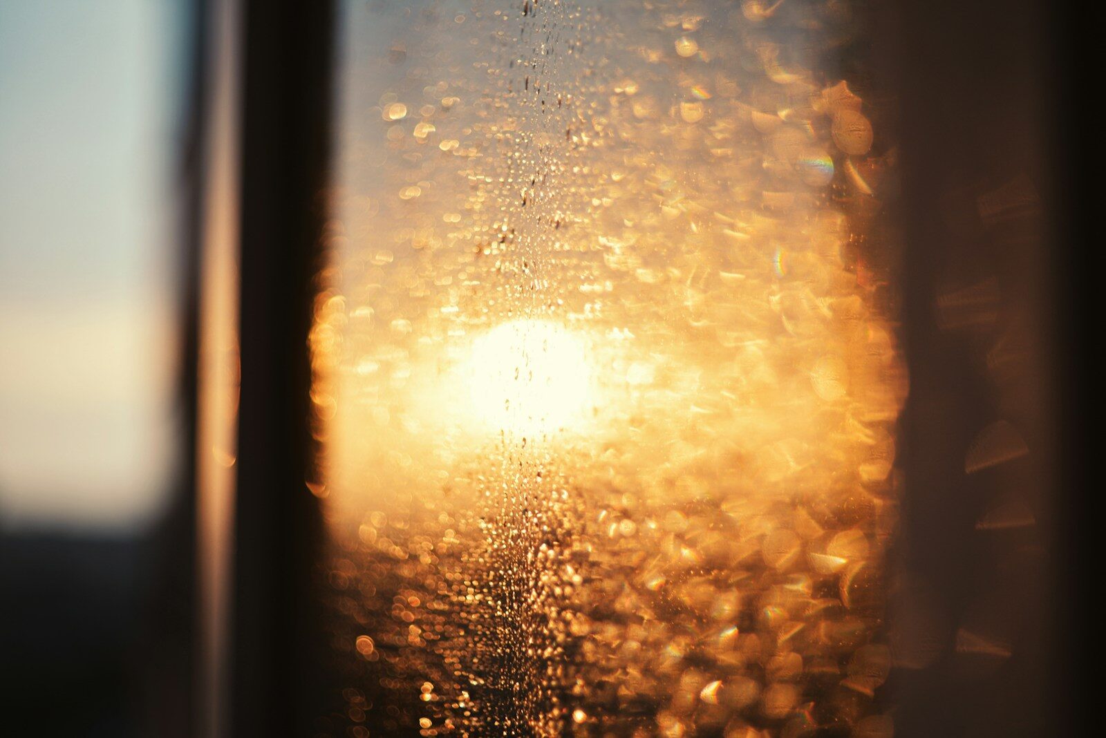 Sunlight shining through a wet window pane.