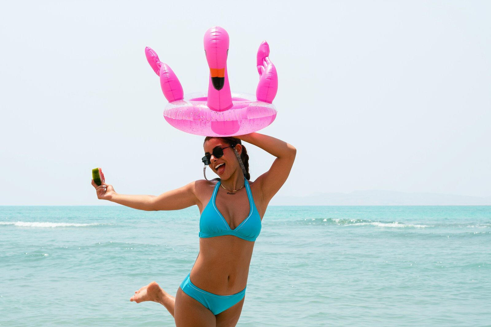 Woman in bikini with flamingo float on head