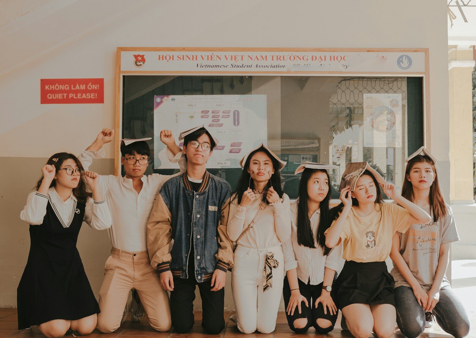 seven persons kneeling near wall during daytime