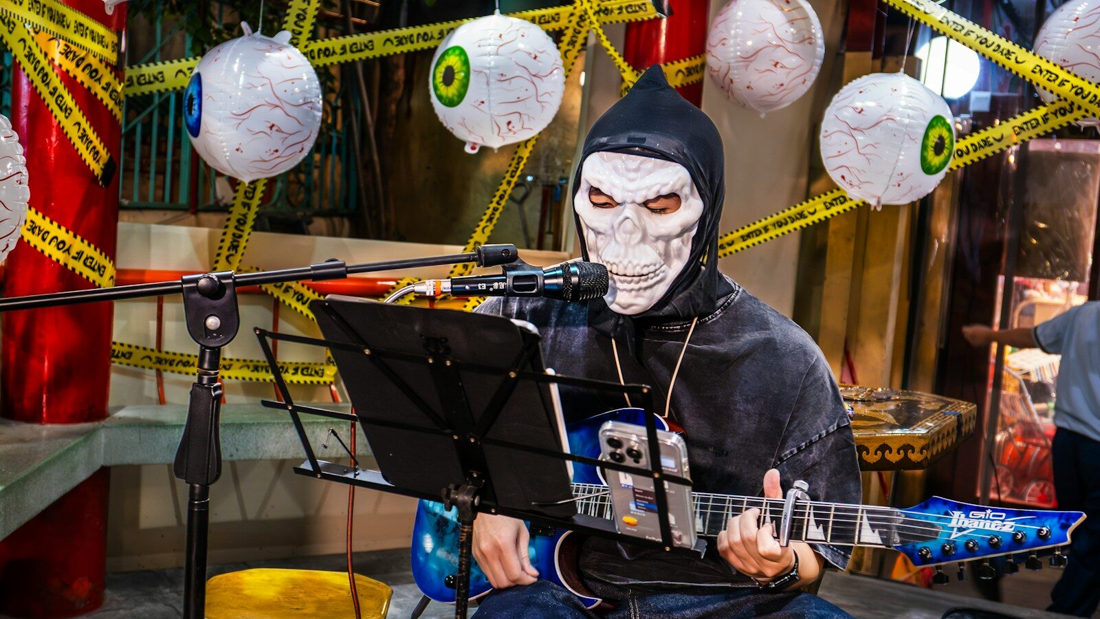 Person in grim reaper costume plays guitar